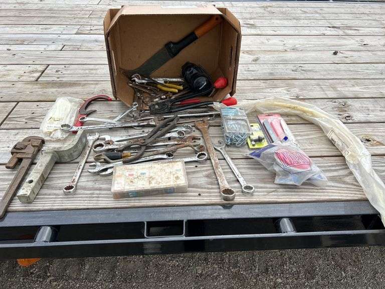 Box of tools including rigid pipe wrench, wrenches, link coil chain, cable ties and more