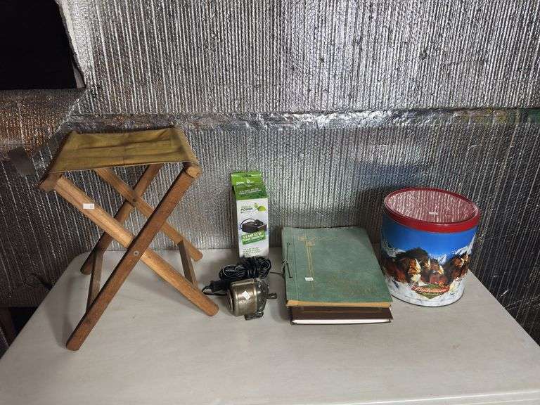 Power converter, scrapbooks, Budweiser tin, and camping chair.