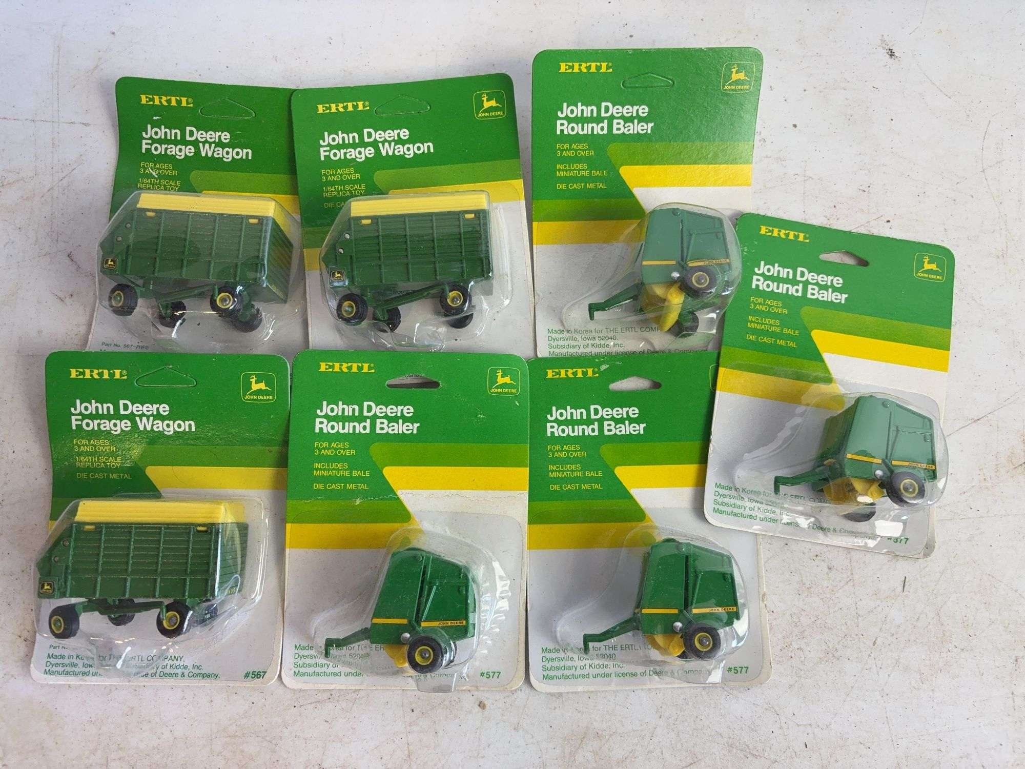 (7) John Deere diecast model toys - (3) forage wagons and (4) round balers