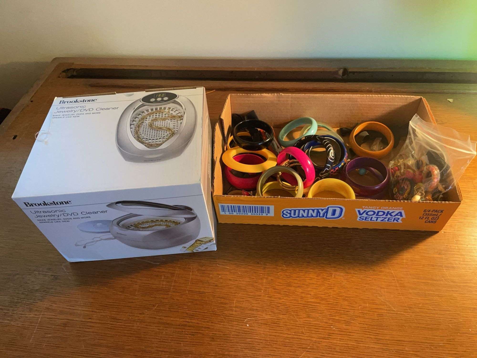 Flat of costume jewelry - mostly bracelets and earrings, and jewelry cleaner