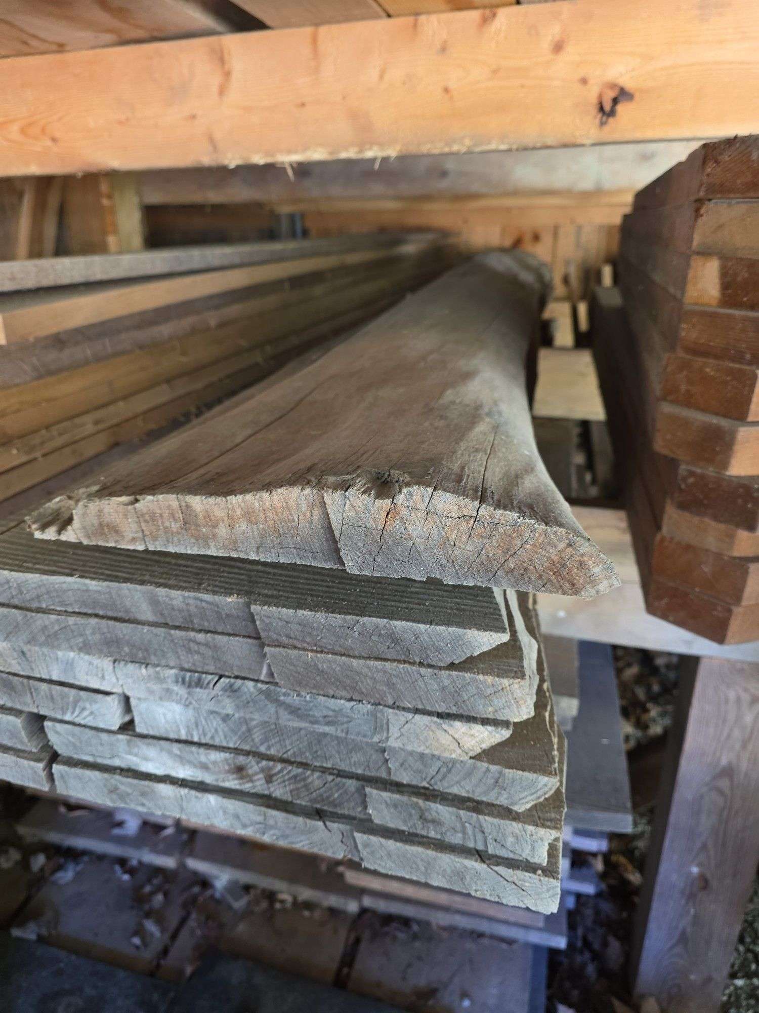 Assortment of stacked lumber. Under roof, lots of 8ft & 10ft variety of species Buyer responsible fo