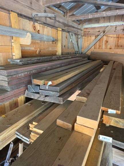 Assortment of stacked lumber. Under roof, lots of 8ft & 10ft variety of species Buyer responsible fo