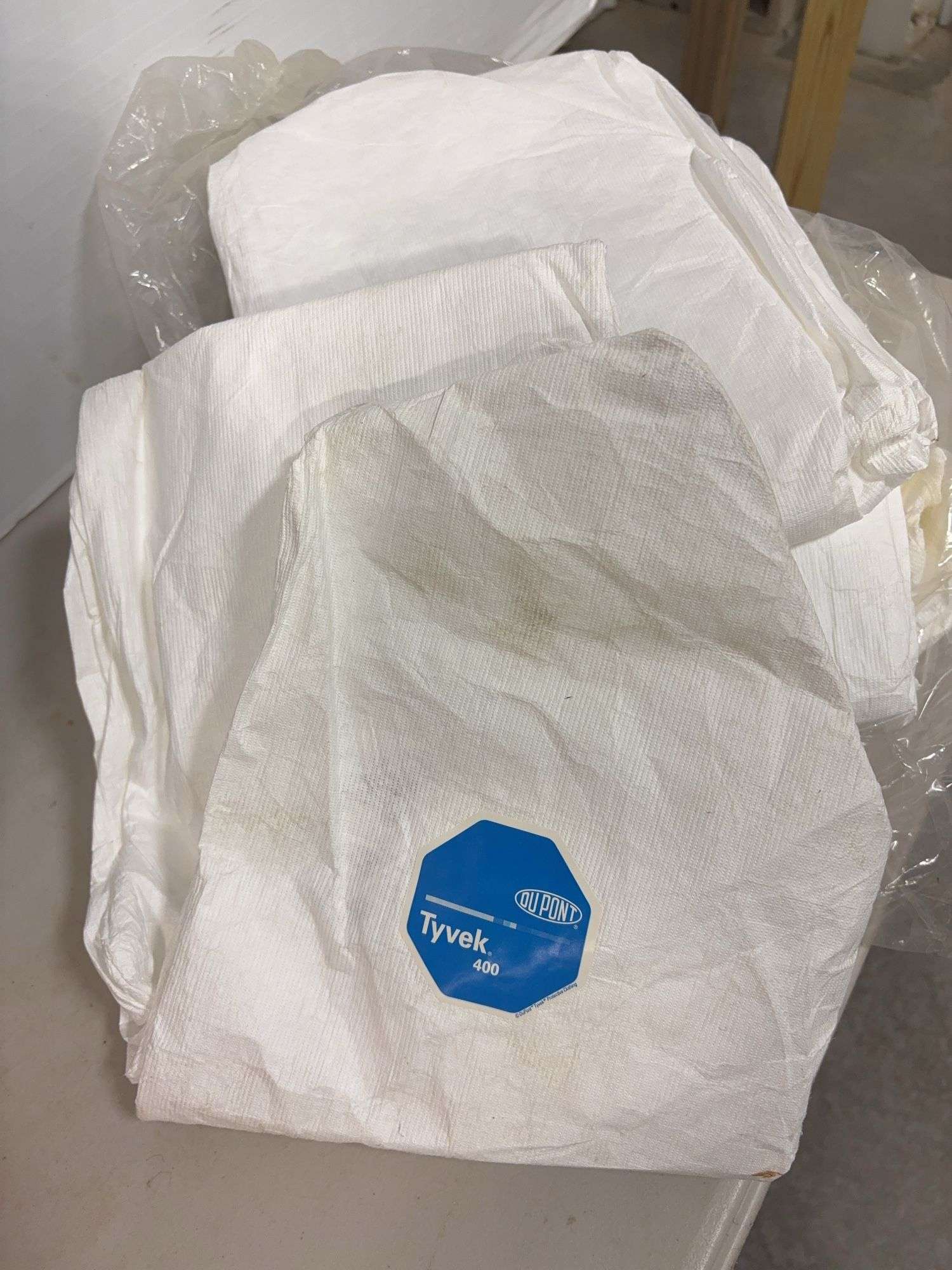 Lot of shop supplies including scotch tape dispenser, fire extinguisher, paint suits and more