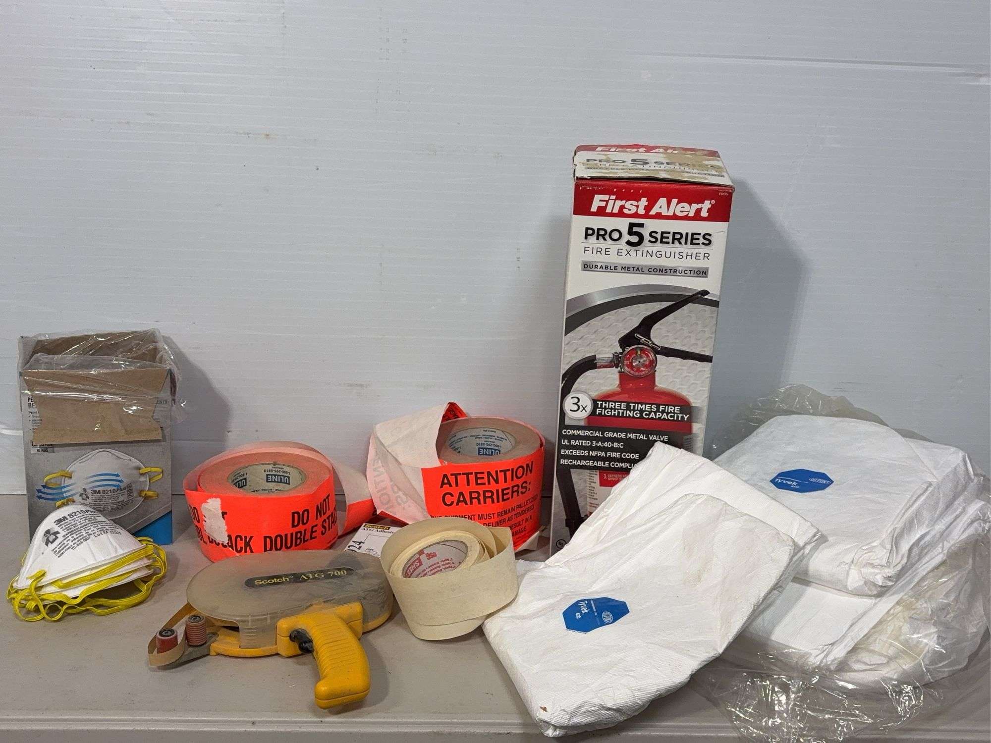 Lot of shop supplies including scotch tape dispenser, fire extinguisher, paint suits and more