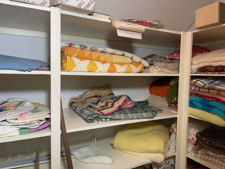 Closet of linens, quilts, dolls, and more