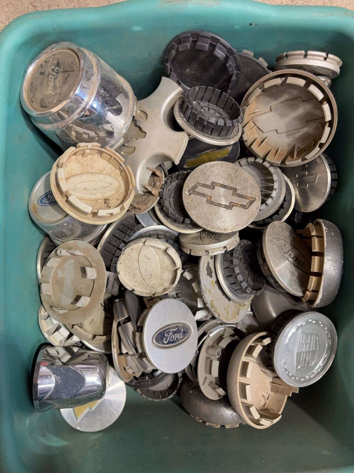 Tote of Chevy and Ford hub caps and parts