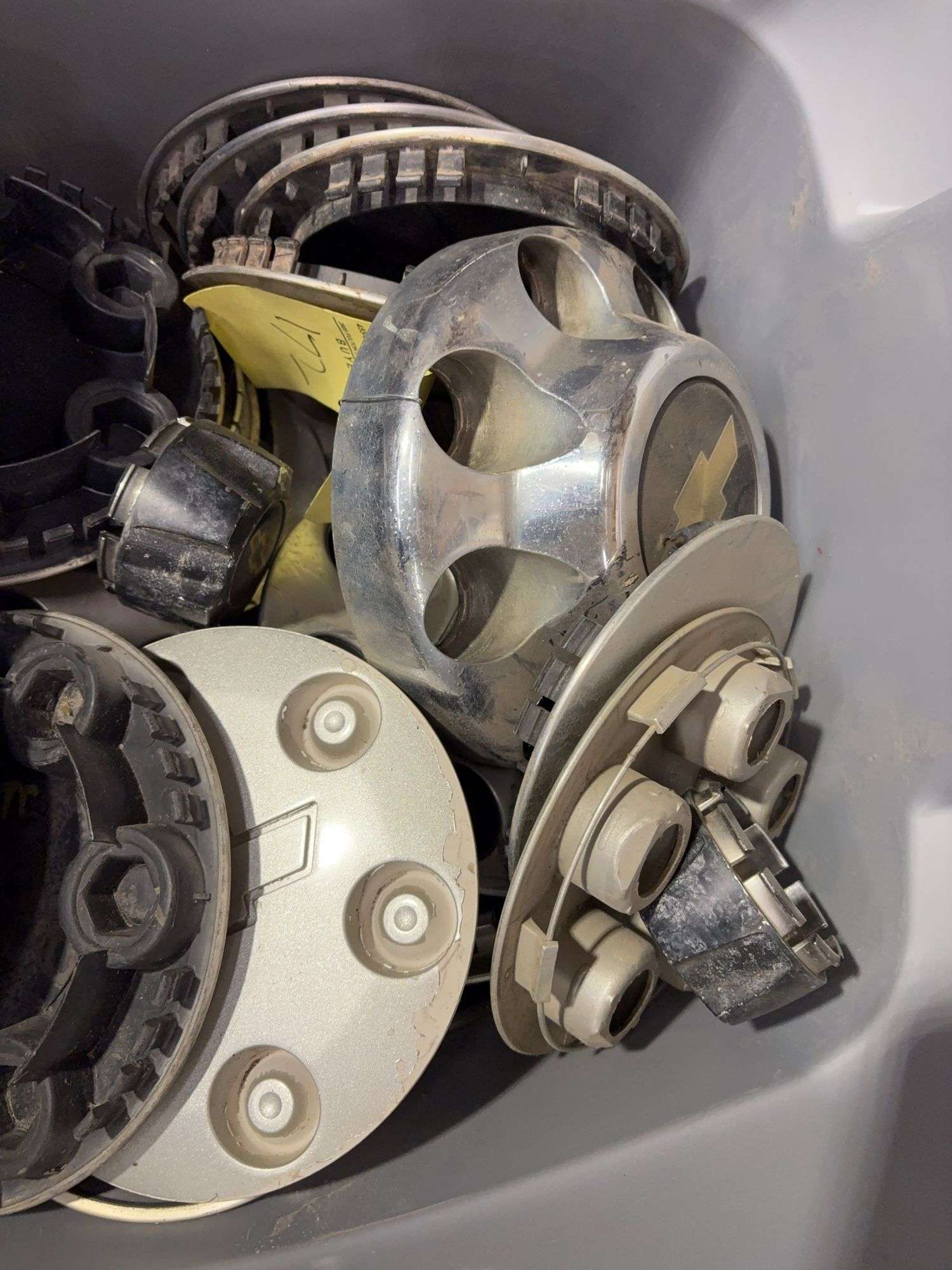 Tote of Chevy hub caps and parts