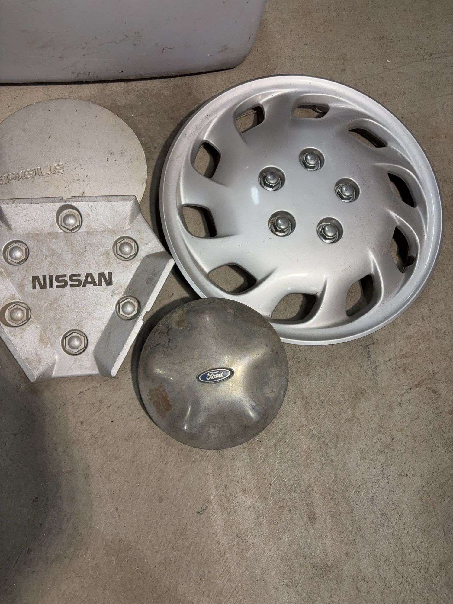 Tote of hub caps and parts -Nissan, Chevy, Ford and more