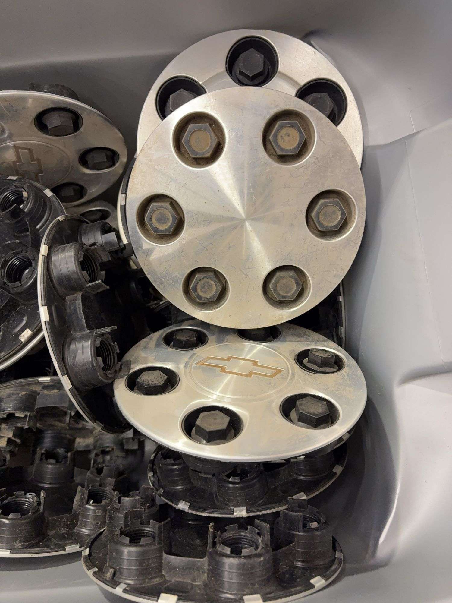 Tote of Chevy hub caps and parts