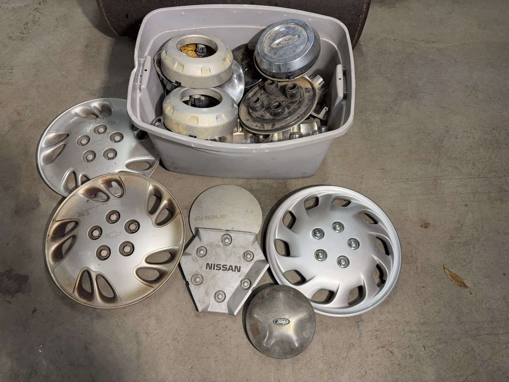 Tote of hub caps and parts -Nissan, Chevy, Ford and more