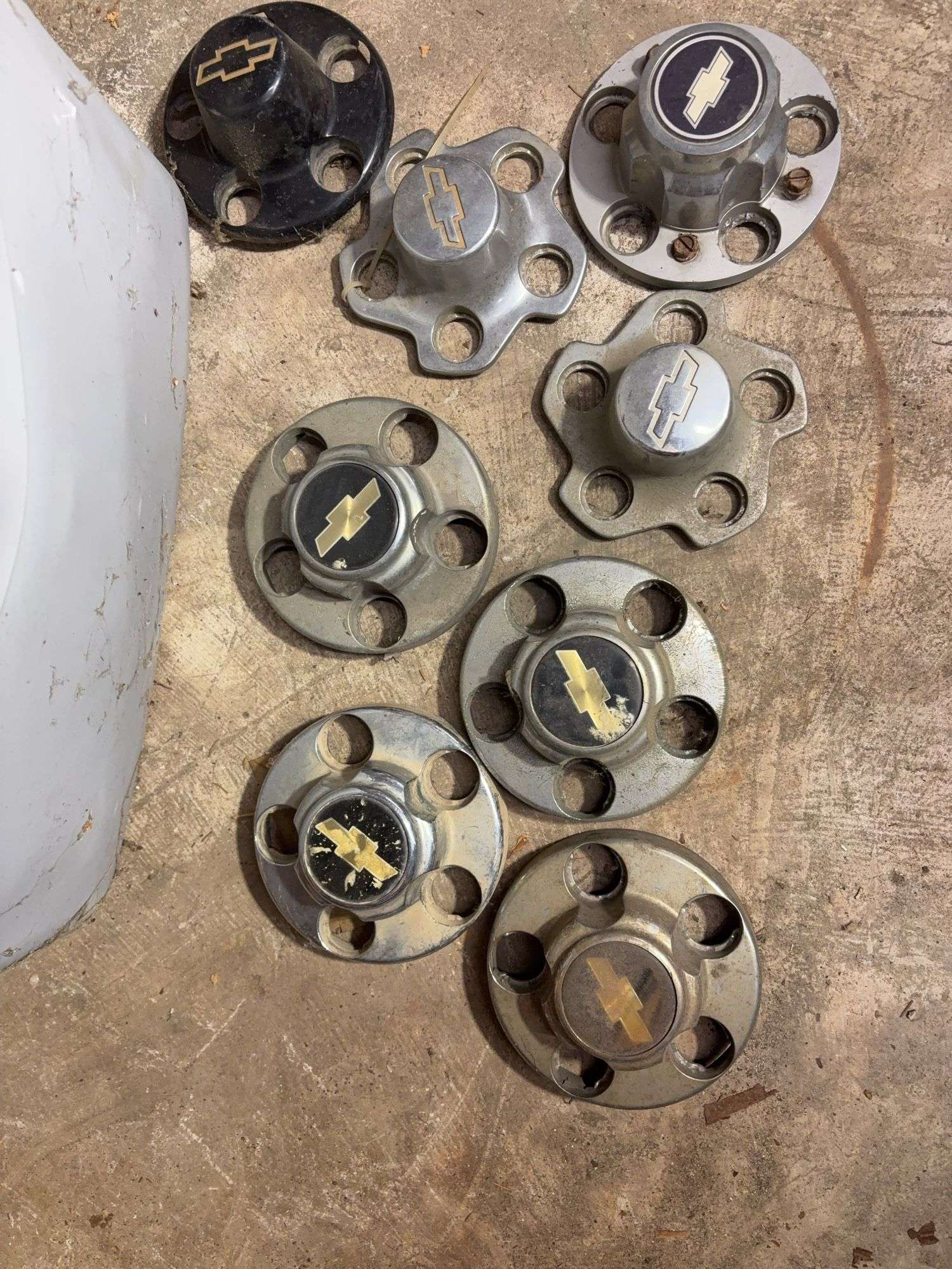 Tote of Chevy hub caps and parts