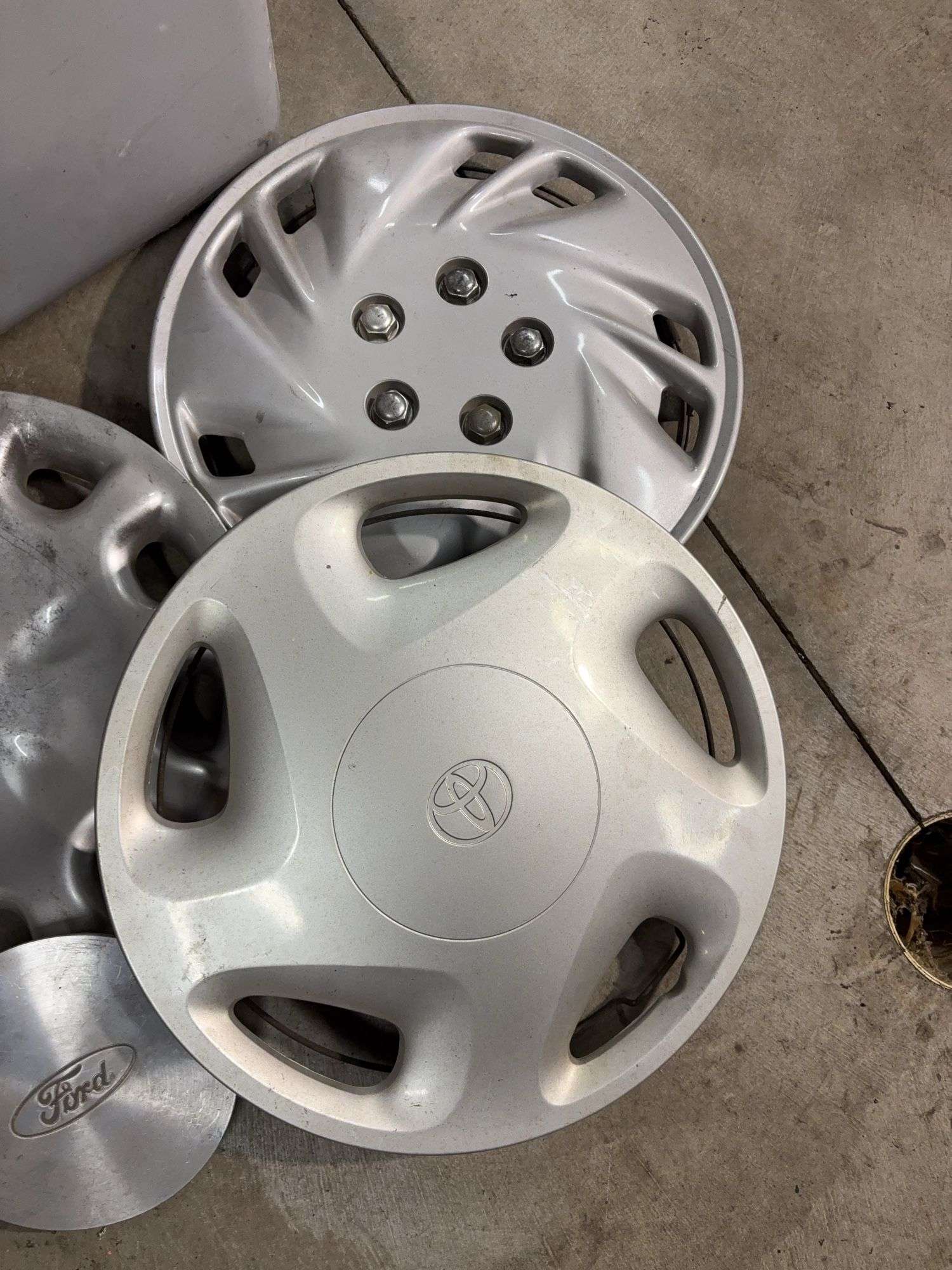 Tote of miscellaneous hub caps and parts -Ford, Toyota and more