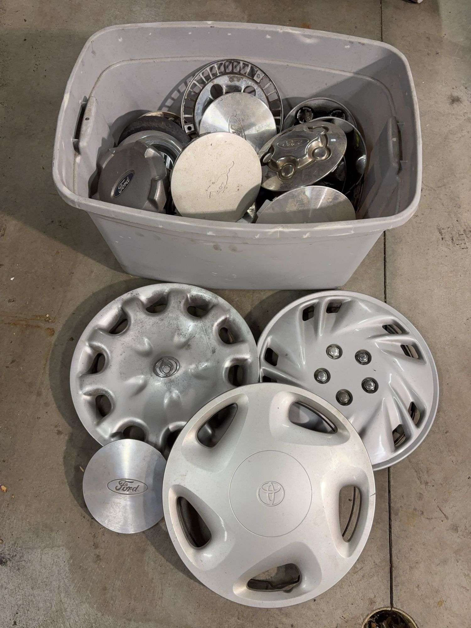Tote of miscellaneous hub caps and parts -Ford, Toyota and more