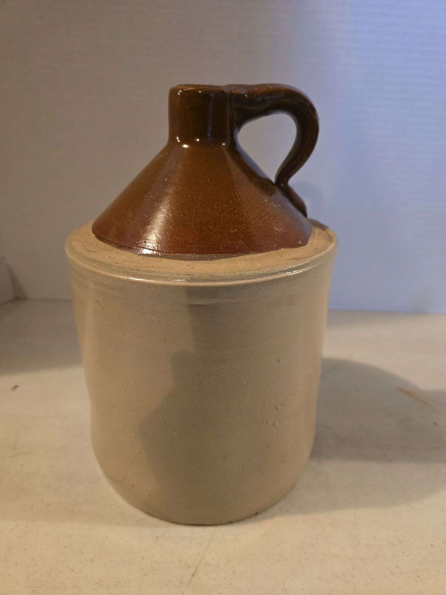 BROWN TOP 1 GALLON CROCK JUG HAS HAIRLINE ON BOTTOM