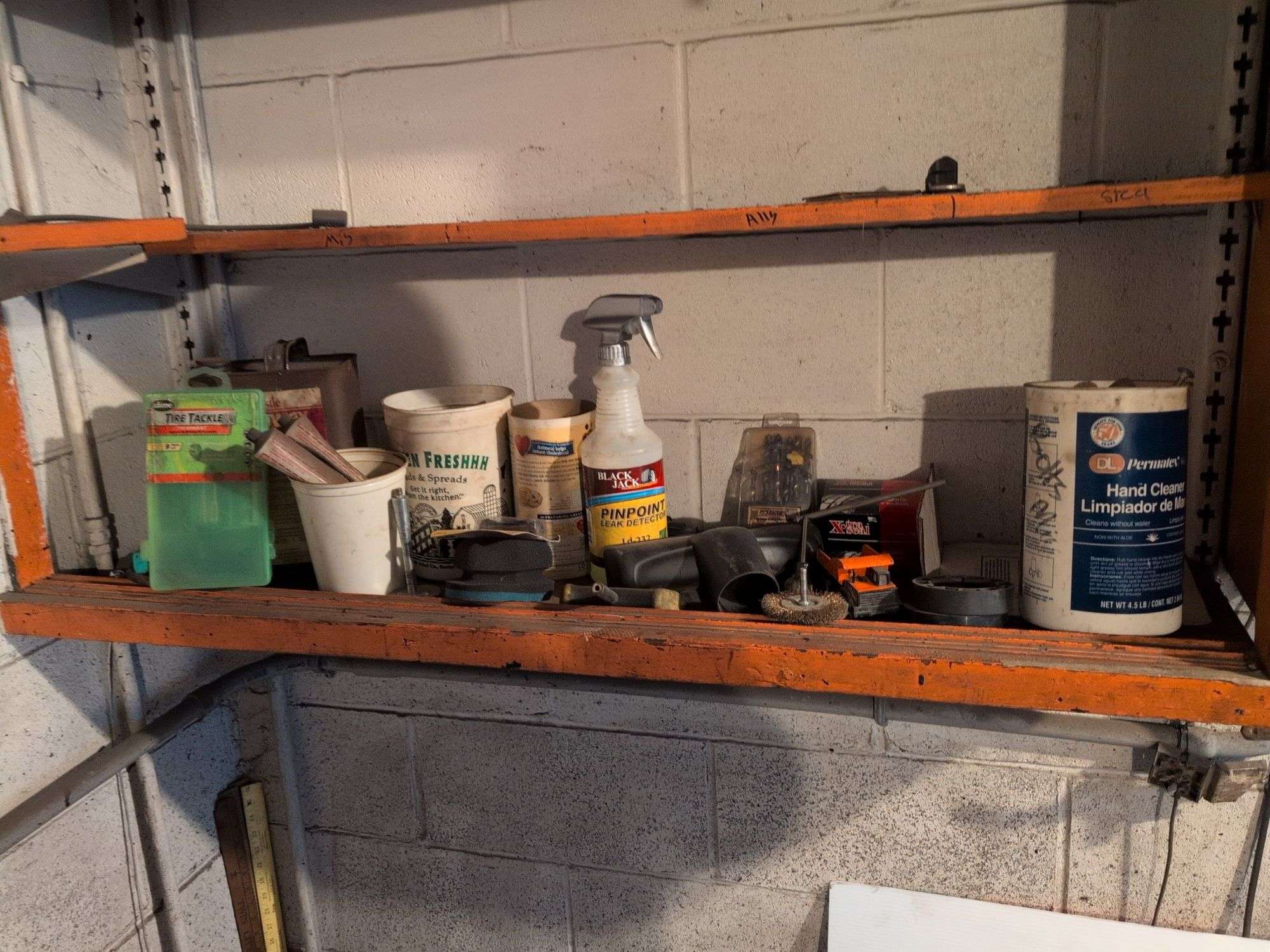 Shelf of drill bits, wire grinder, toy Tonka truck, and more