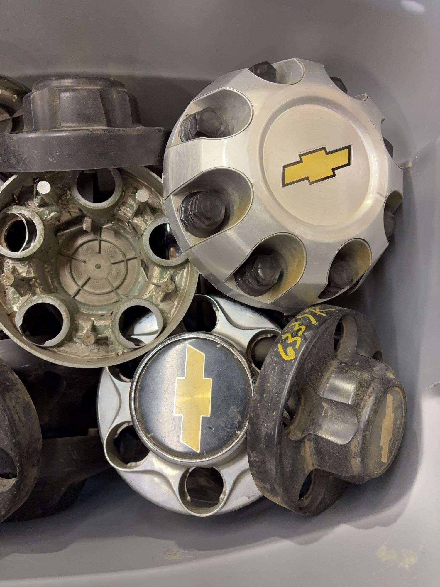 Tote of Chevy hub caps and parts