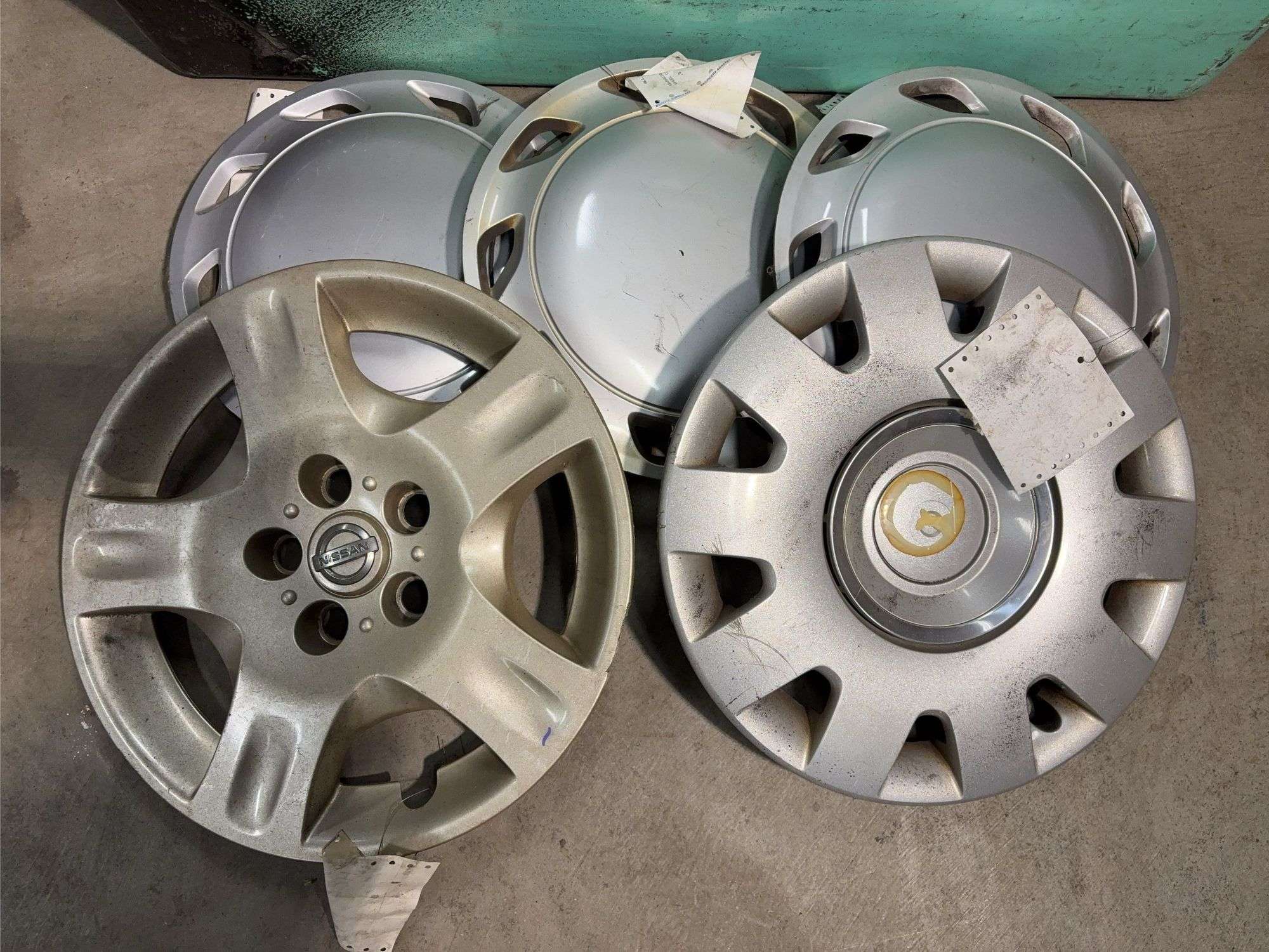 Large tote of Nissan hub caps and parts