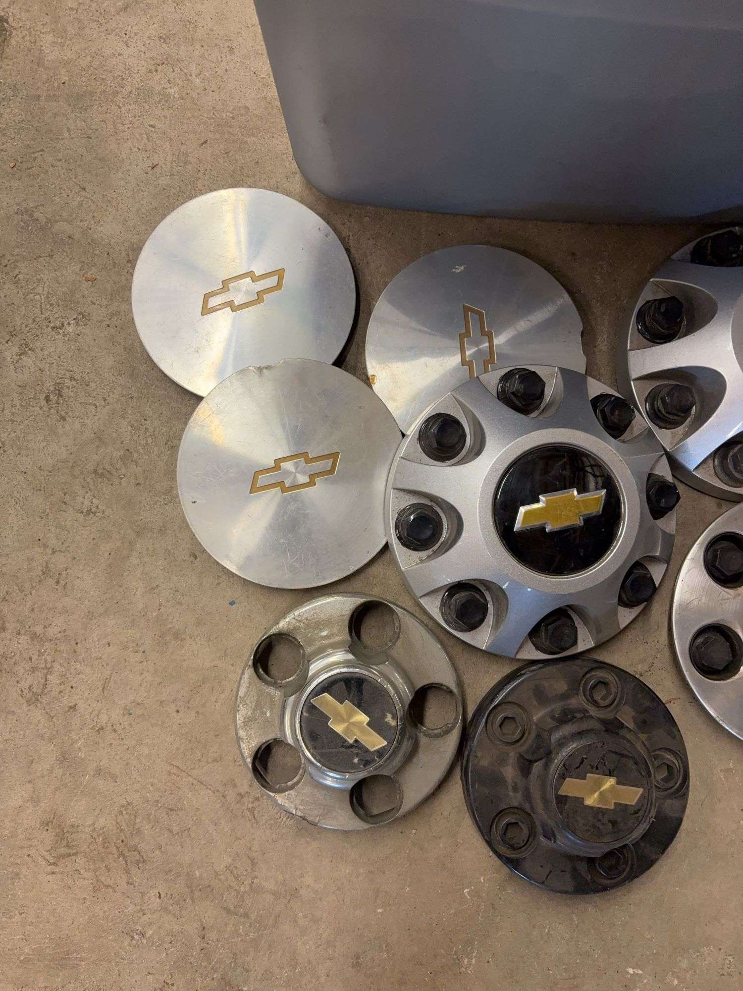 Tote of Chevy hub caps and parts