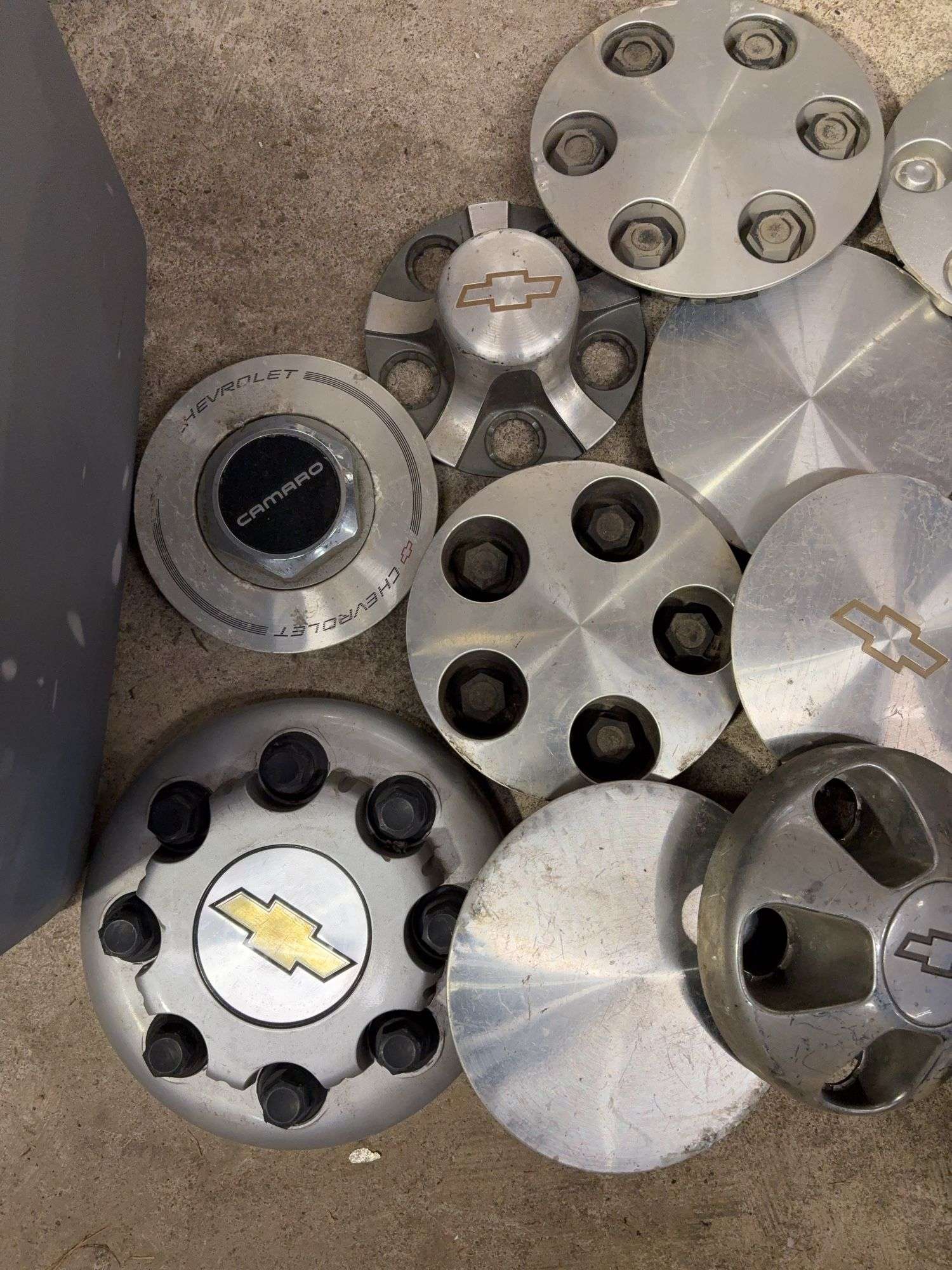 Tote of Chevy hub caps and parts
