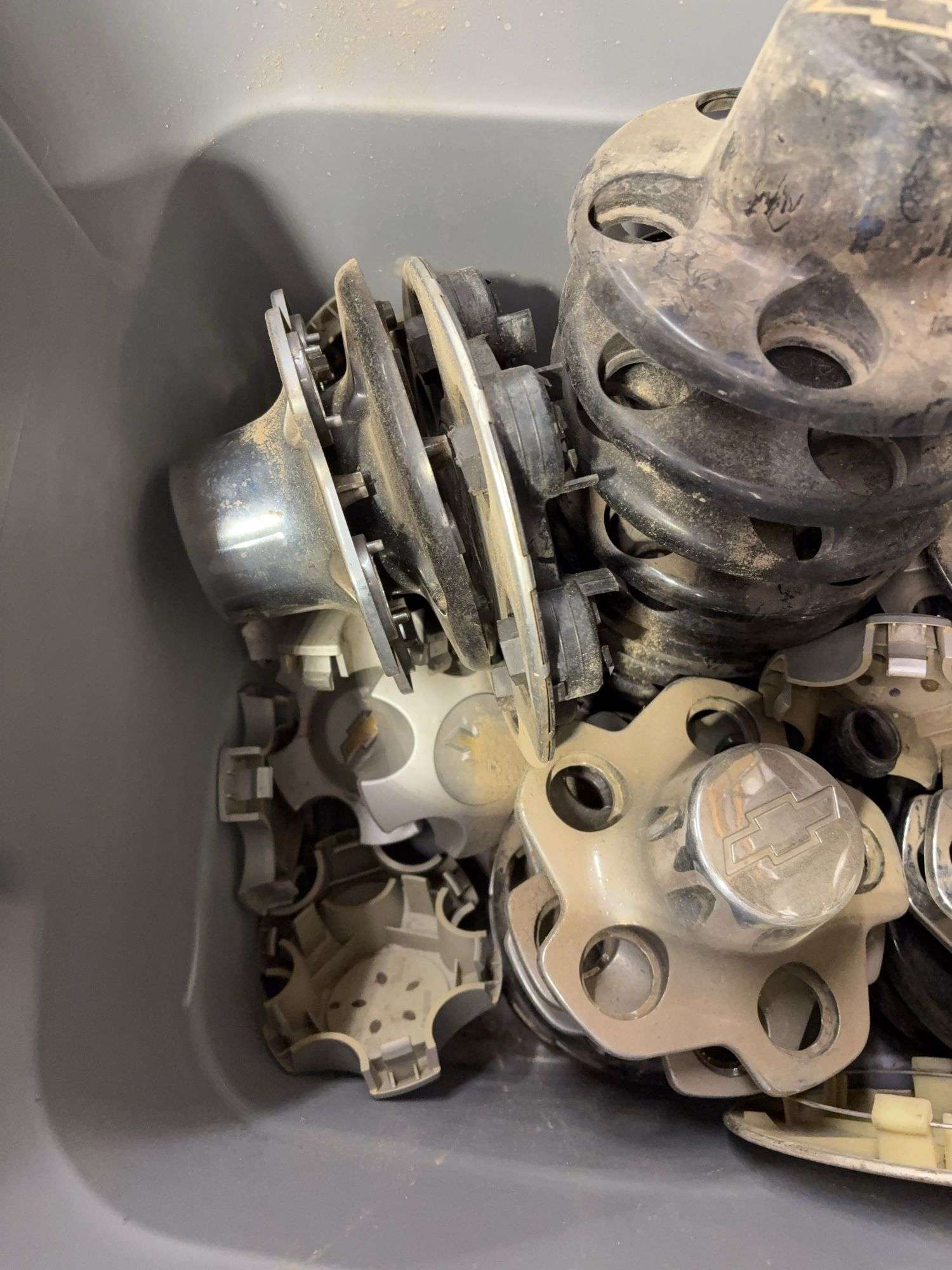 Tote of Chevy hub caps and parts