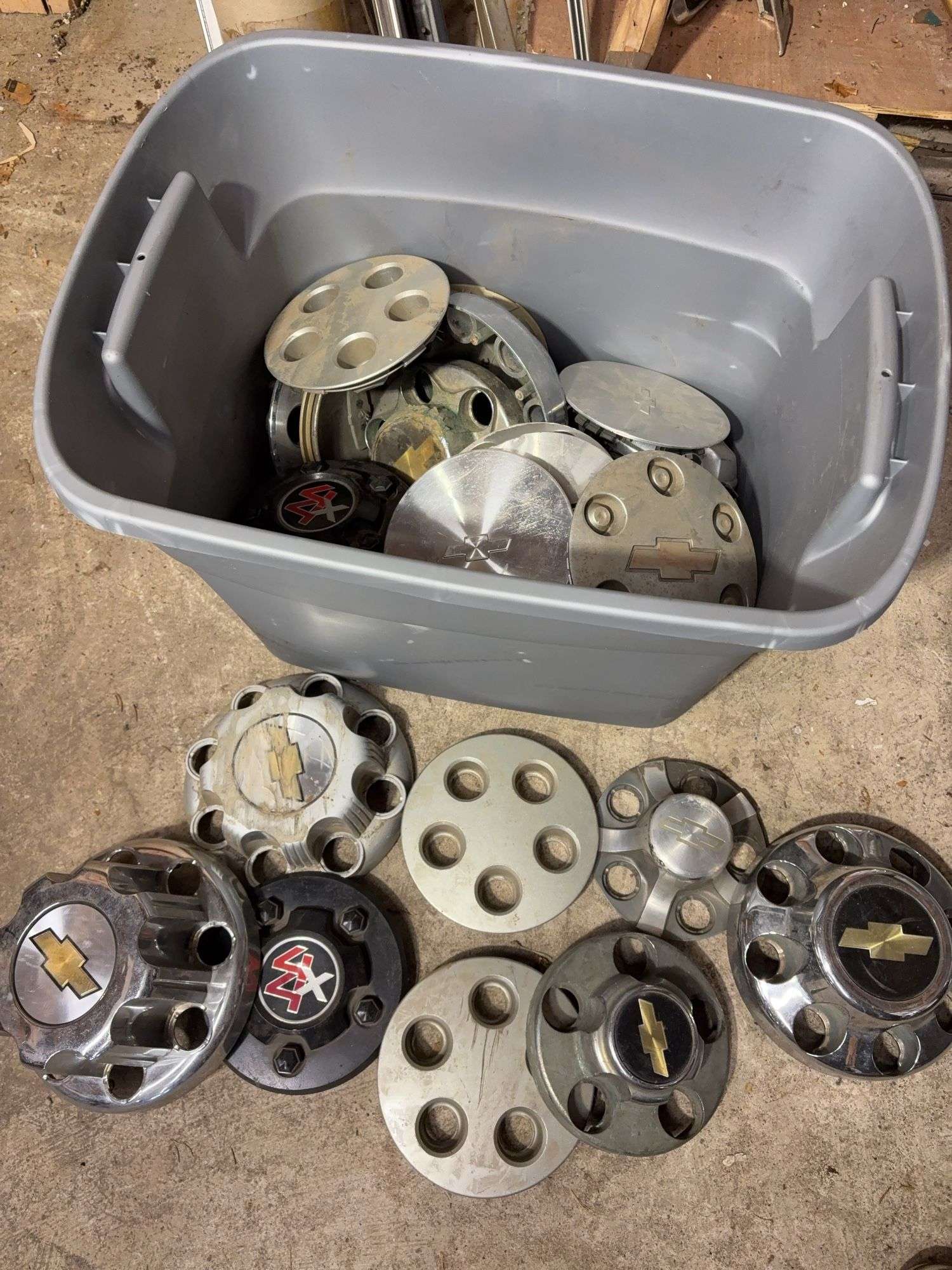 Tote of Chevy hub caps and parts