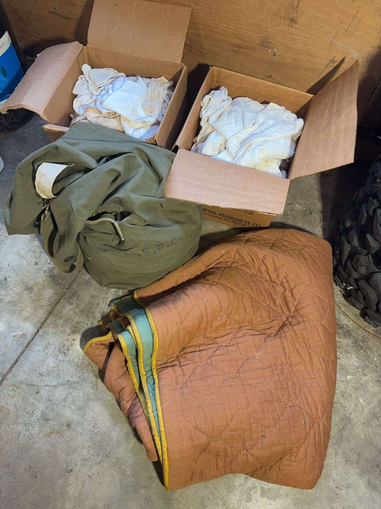 Boxes of rags, military bag, and blankets