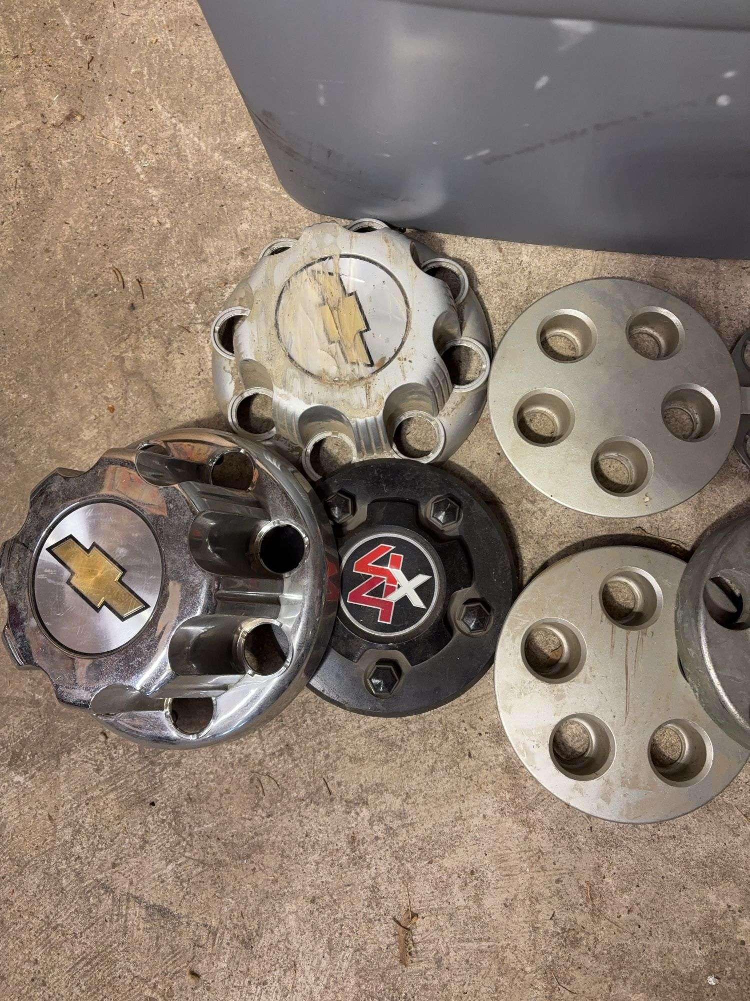 Tote of Chevy hub caps and parts