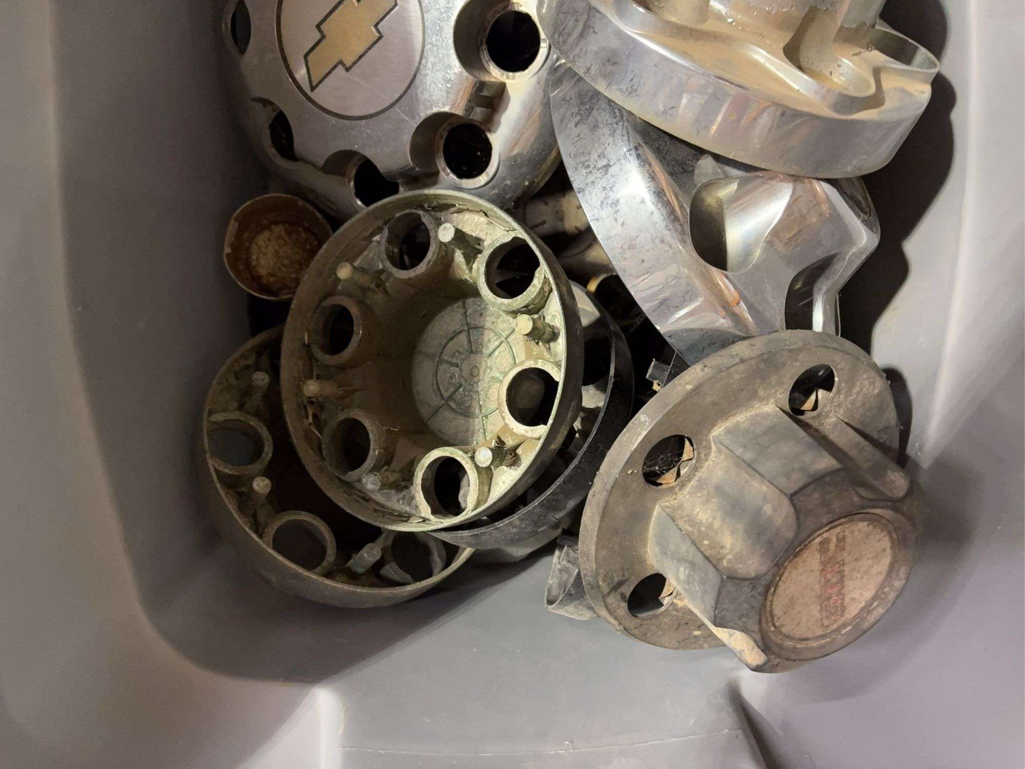 Tote of GMC hub caps and parts