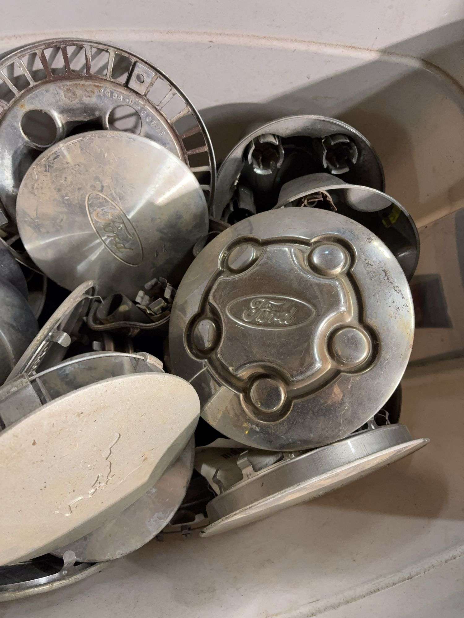 Tote of miscellaneous hub caps and parts -Ford, Toyota and more