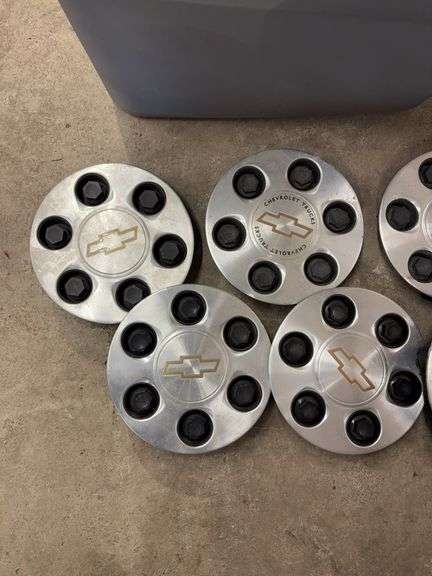 Tote of Chevy hub caps and parts