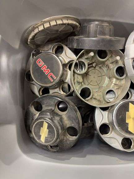 Tote of Chevy hub caps and parts
