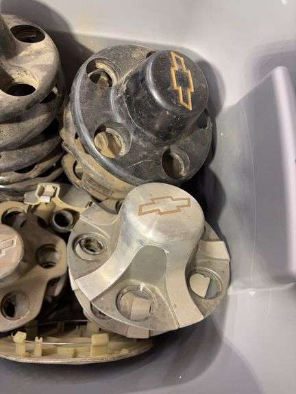 Tote of Chevy hub caps and parts