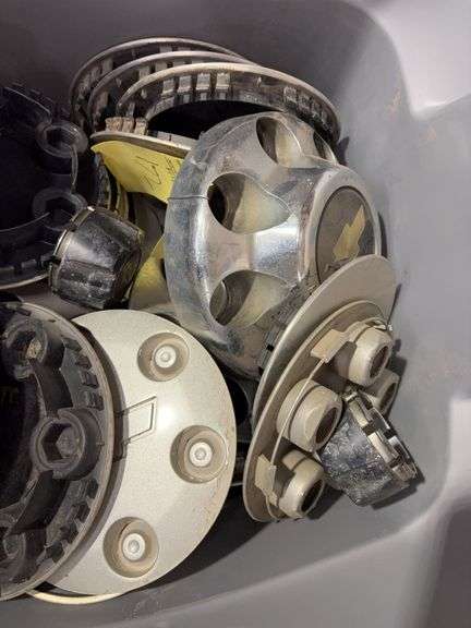 Tote of Chevy hub caps and parts