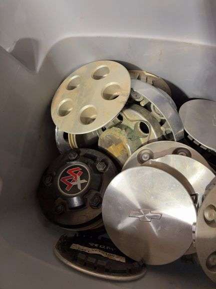 Tote of Chevy hub caps and parts