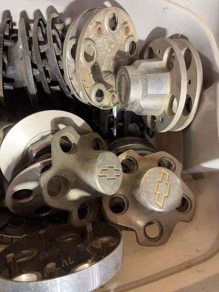 Tote of Chevy hub caps and parts