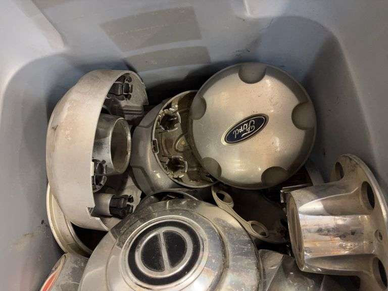 Tote of Ford hub caps and parts and small tote of Wheel cover locks