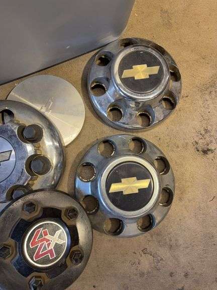 Large tote of Chevy hub caps and parts