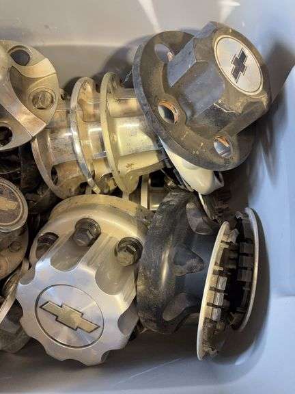 Large tote of Chevy hub caps and parts