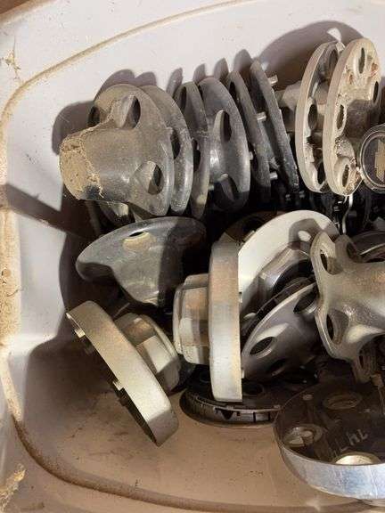 Tote of Chevy hub caps and parts
