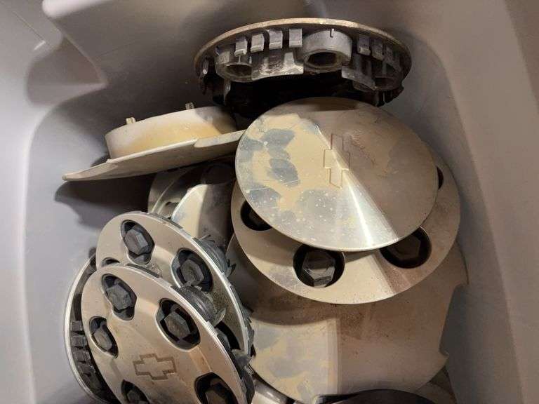 Tote of Chevy hub caps and parts