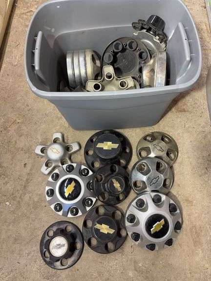 Tote of Chevy hub caps and parts