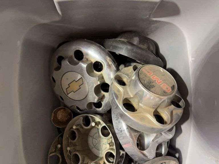 Tote of GMC hub caps and parts