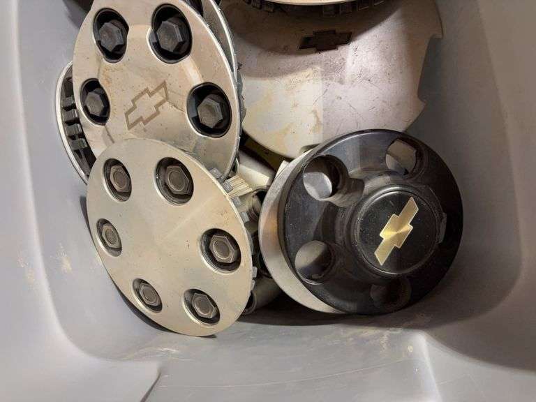 Tote of Chevy hub caps and parts