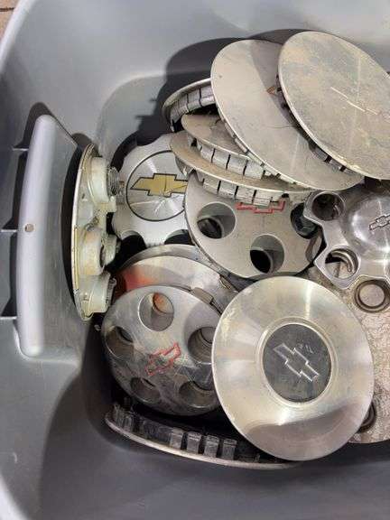 Tote of Chevy hub caps and parts