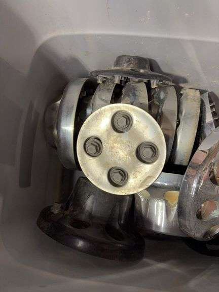 Tote of Chevy hub caps and parts