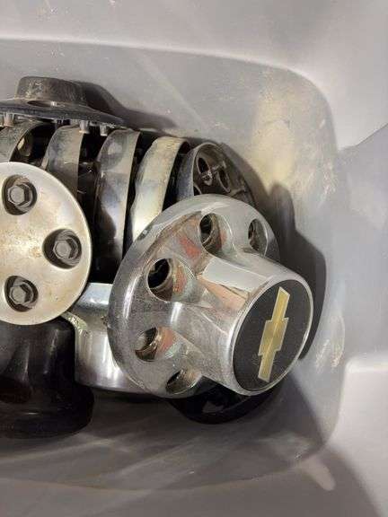 Tote of Chevy hub caps and parts