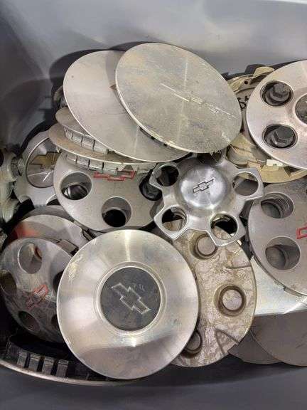 Tote of Chevy hub caps and parts