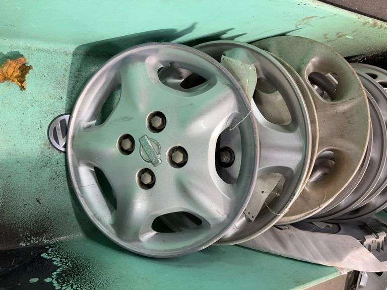 Large tote of Nissan hub caps and parts