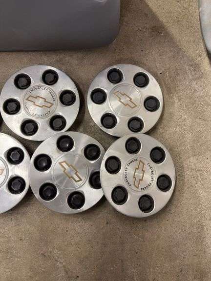 Tote of Chevy hub caps and parts