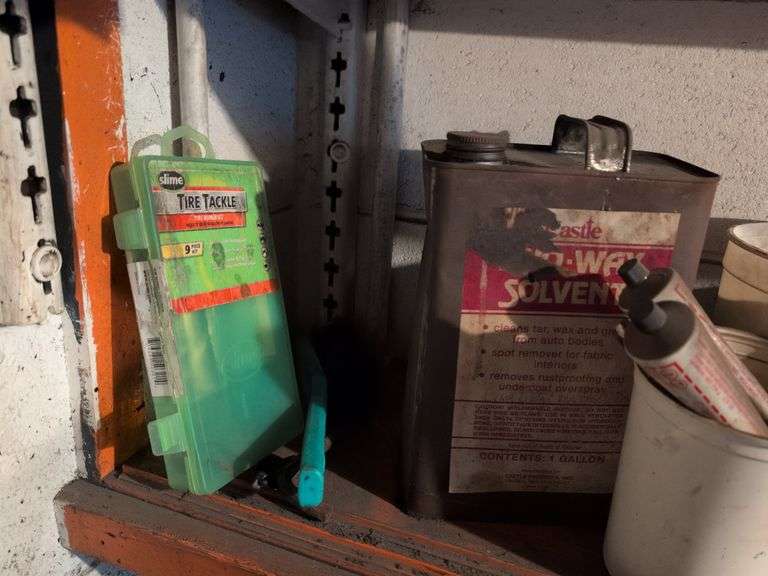 Shelf of drill bits, wire grinder, toy Tonka truck, and more